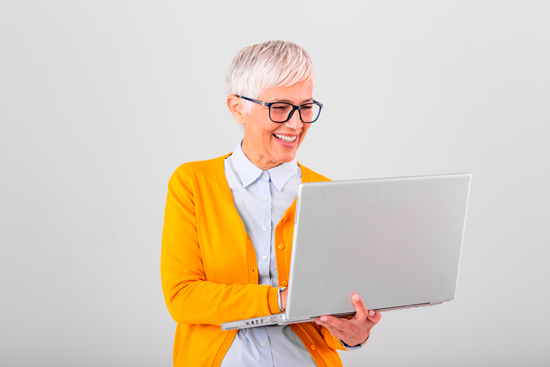 Femme aux lunettes et cheveux blancs avec un ordinateur portable