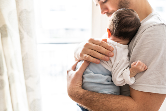 Homme avec un nouveau-né dans les bras