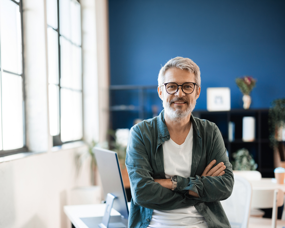 Homme assis sur un bureau dans un open-space